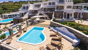 A resort with multiple swimming pools, lounge areas, and a hillside view. - 9 Muses Villa Thalia 5 BR with private pool! (Mykonos)