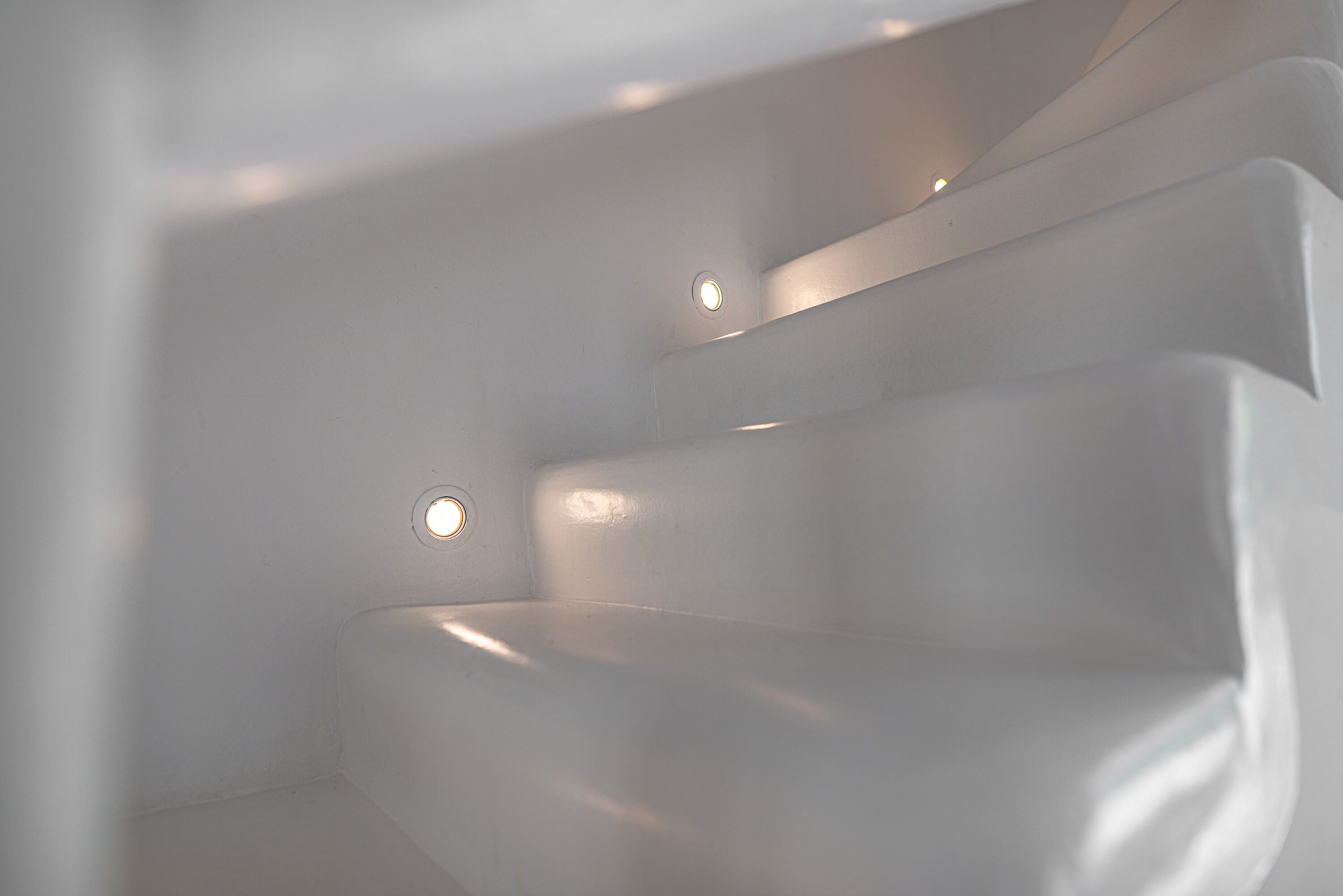 Ein modernes, minimalistisches Badezimmer mit schlanker, geschwungener Form und eingelassener Beleuchtung.