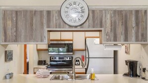 A modern kitchen with a built-in oven, microwave, and stainless steel sink. - The Cozy Place - Pointe Royale Condo Perfect for Couples! (Branson)