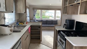 Una cucina compatta con piano cottura integrato, lavello e finestra vista giardino.