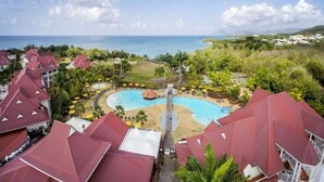 A resort with a central swimming pool, surrounded by palm trees and a view of the ocean. - Studio Tropical Avec vue sur le Rocher du Diamant (Sainte-Luce)