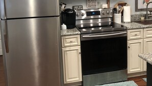 A kitchen with stainless steel appliances, including a refrigerator and microwave, and a stove. - Historic Home Steps from Florida Southern, Lake Morton and Lake Hollingsworth (Lakeland)
