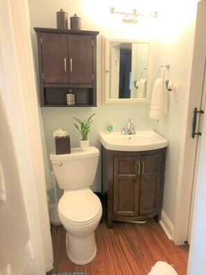 A compact bathroom with a toilet, a sink, and a cabinet above the sink.