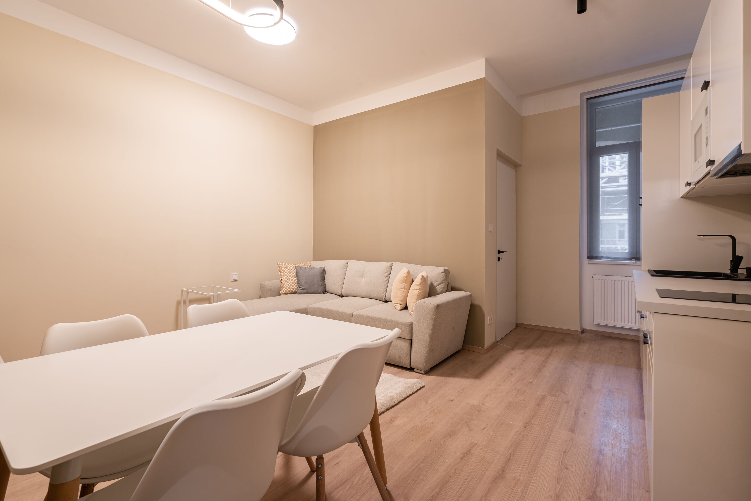 Un appartamento moderno e luminoso con zona pranzo, divano e cucina.
