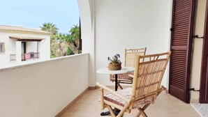 A balcony with a wicker chair, a small round table, and a potted plant. - Christie's Boutique by Corfuescapes  (Corfu)