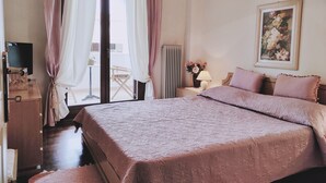 A bedroom with a large bed, a desk, a chair, and a window with curtains. - Christie's Boutique by Corfuescapes  (Corfu)