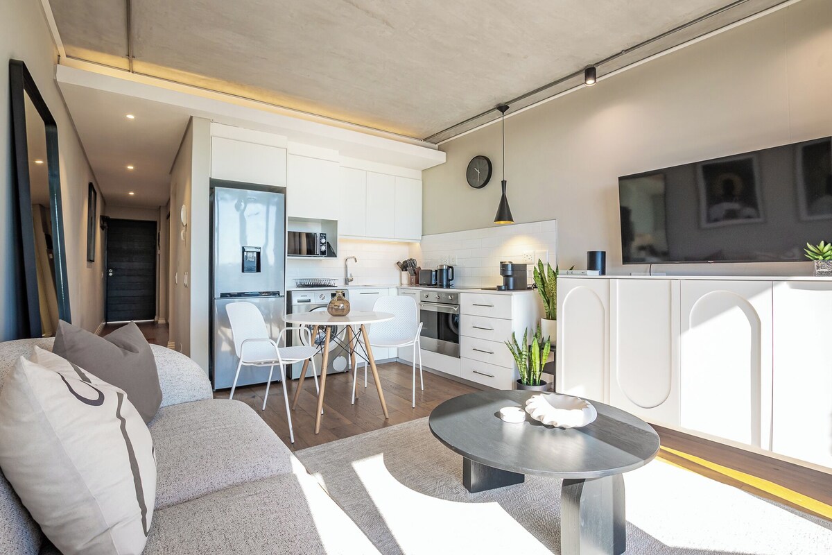 Um apartamento moderno com sala de estar, área de jantar e cozinha.