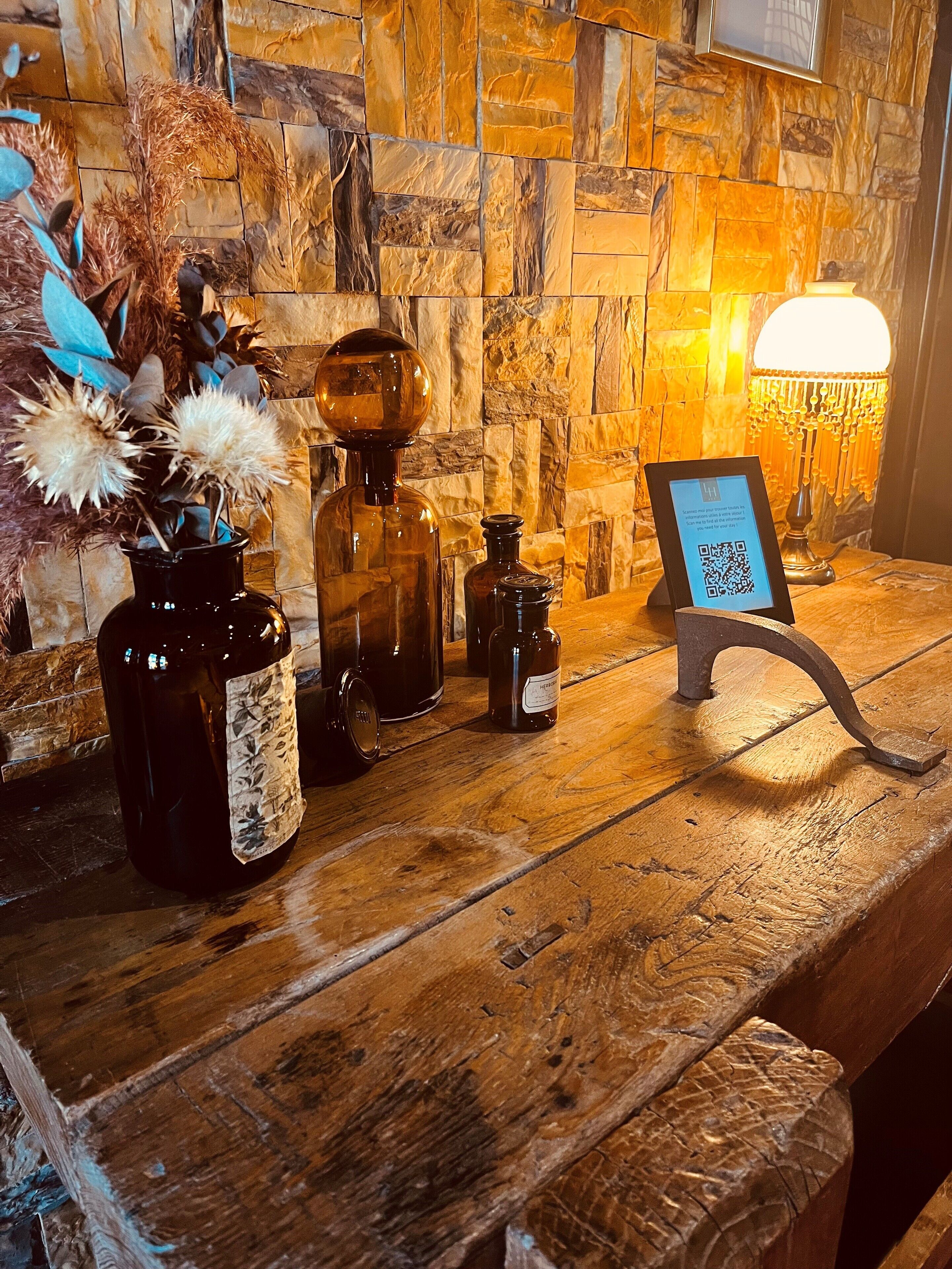 Mostrador de madera con varias botellas y un cartel con un código QR.