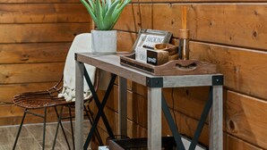 Ein Holzblockhaus-Interieur mit einem Neonzeichen an der Wand, einem Tisch mit einer Topfpflanze und einem Rauchverbot-Schild.