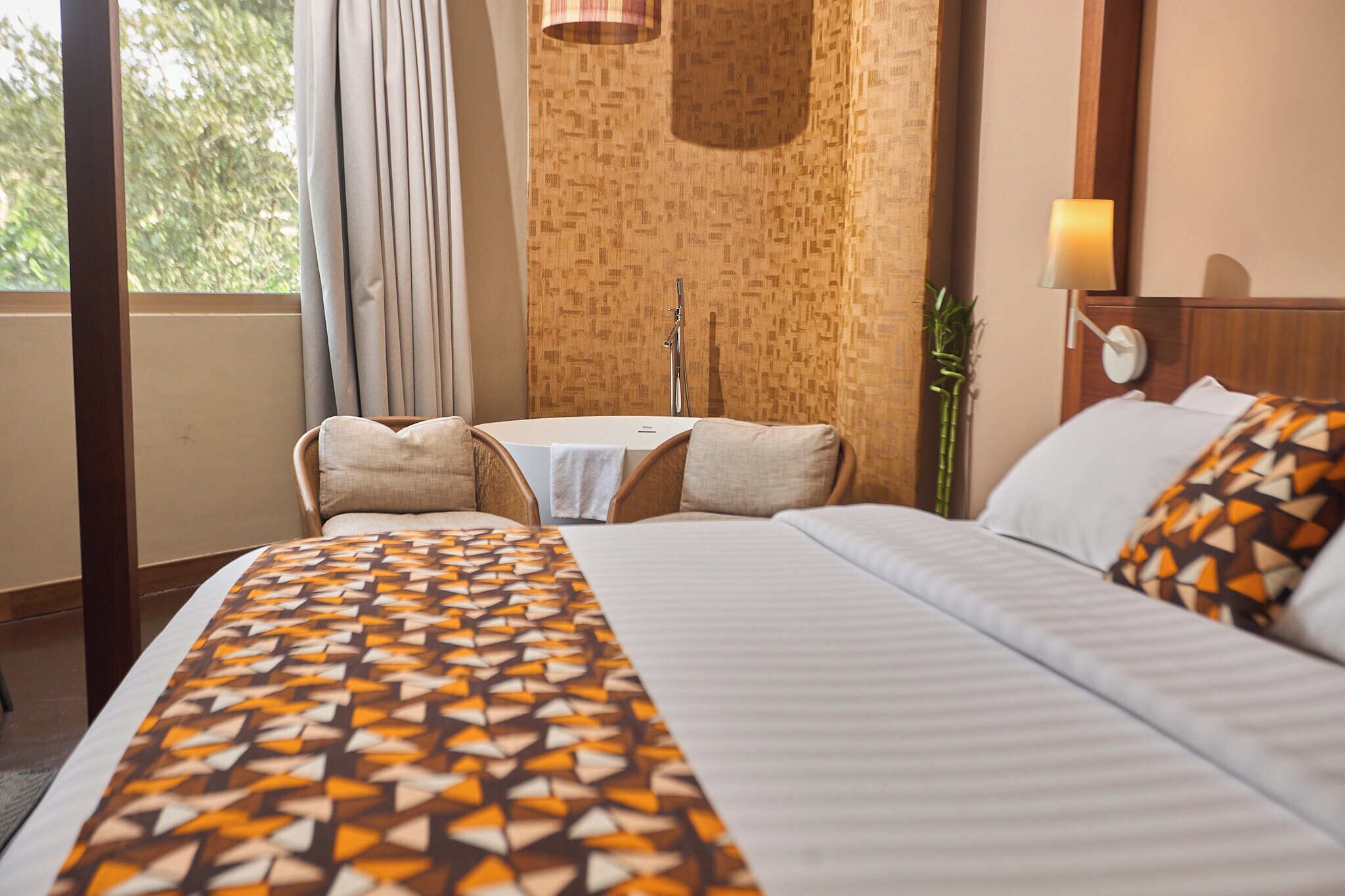 Een hotelkamer met een bed, een klein tafeltje en een stoel.