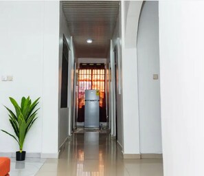Experience the clean and contemporary design of this modern corridor, featuring a grid-like ceiling and polished tile floor.