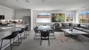 Eine moderne Küche mit Essbereich, ein Wohnzimmer mit einer Couch und ein großes Fenster.