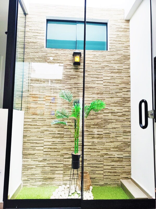 A modern interior with a textured wall, a potted plant, and a small decorative basket.