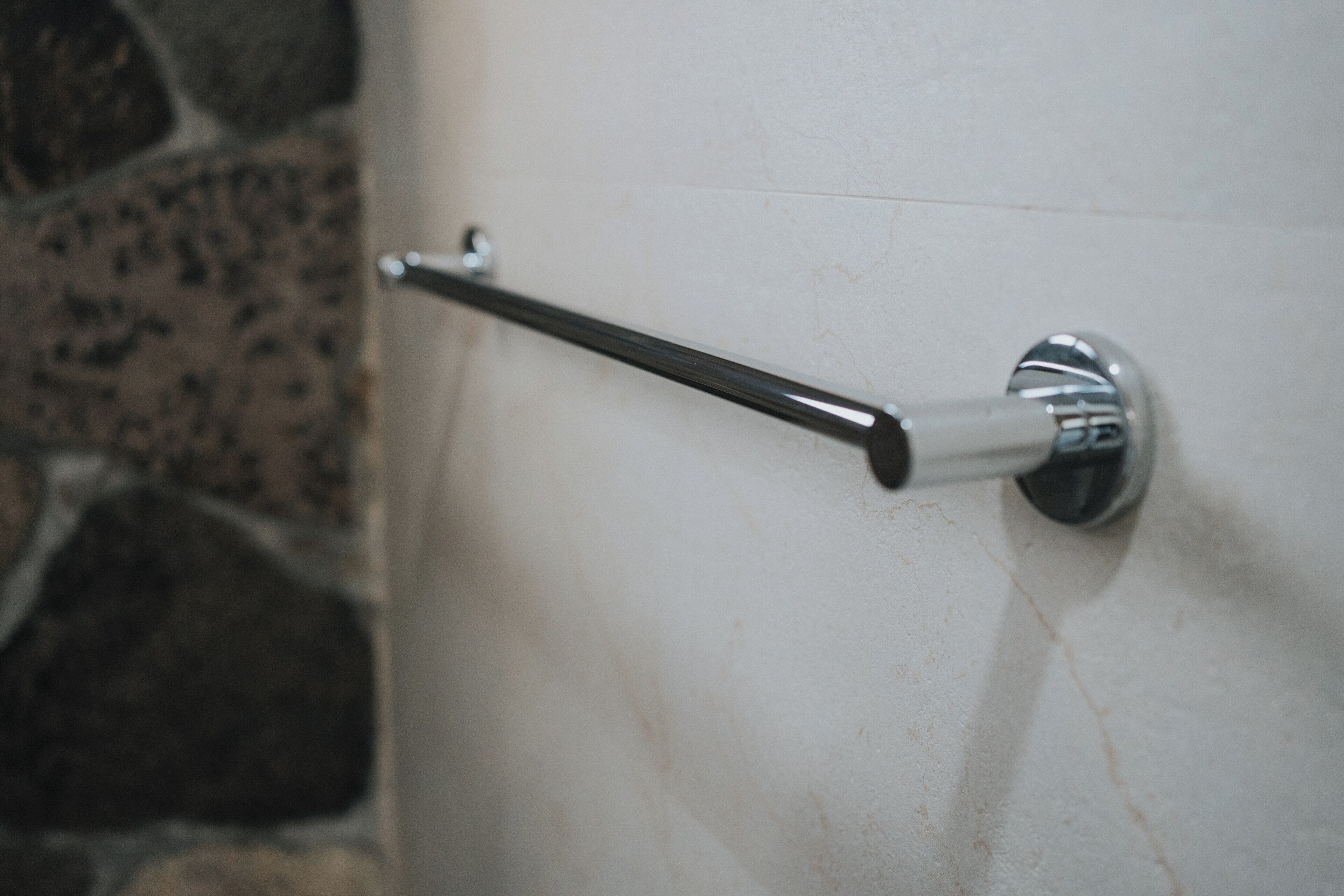 A bathroom with a towel rack mounted on a tiled wall.