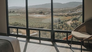 Un dormitorio con un ventanal grande con vistas a un paisaje.