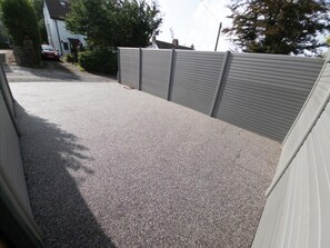 A paved driveway leading to a house with a garage.