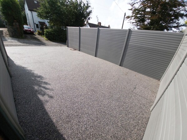 A paved driveway leading to a house with a garage.