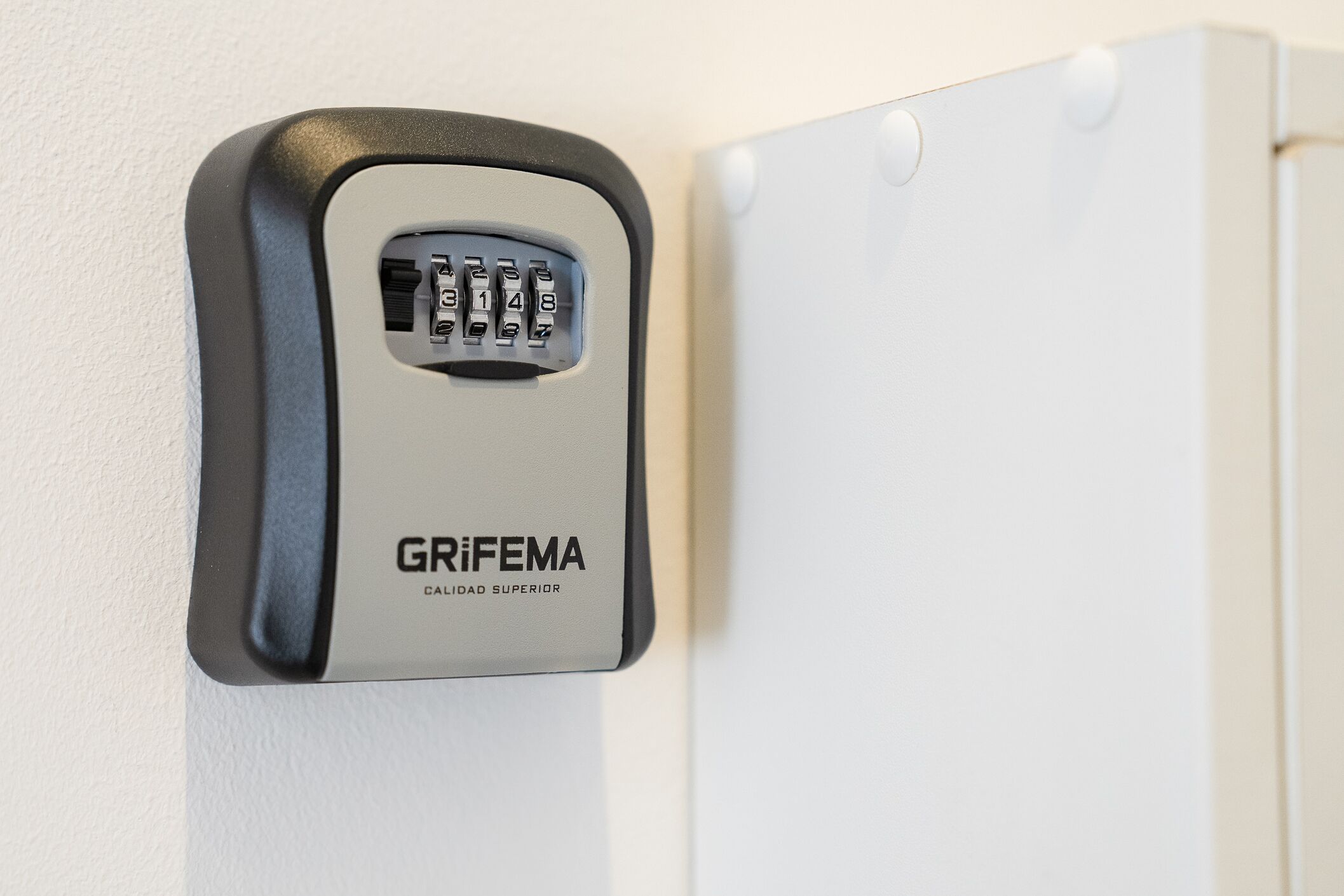 A wall-mounted electronic keypad with the brand name "GRIFEMA" and the phrase "CALIDAD SUPERIOR".