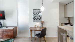 Una cocina moderna con una mesa de comedor de madera, una silla negra y una lámpara colgante.