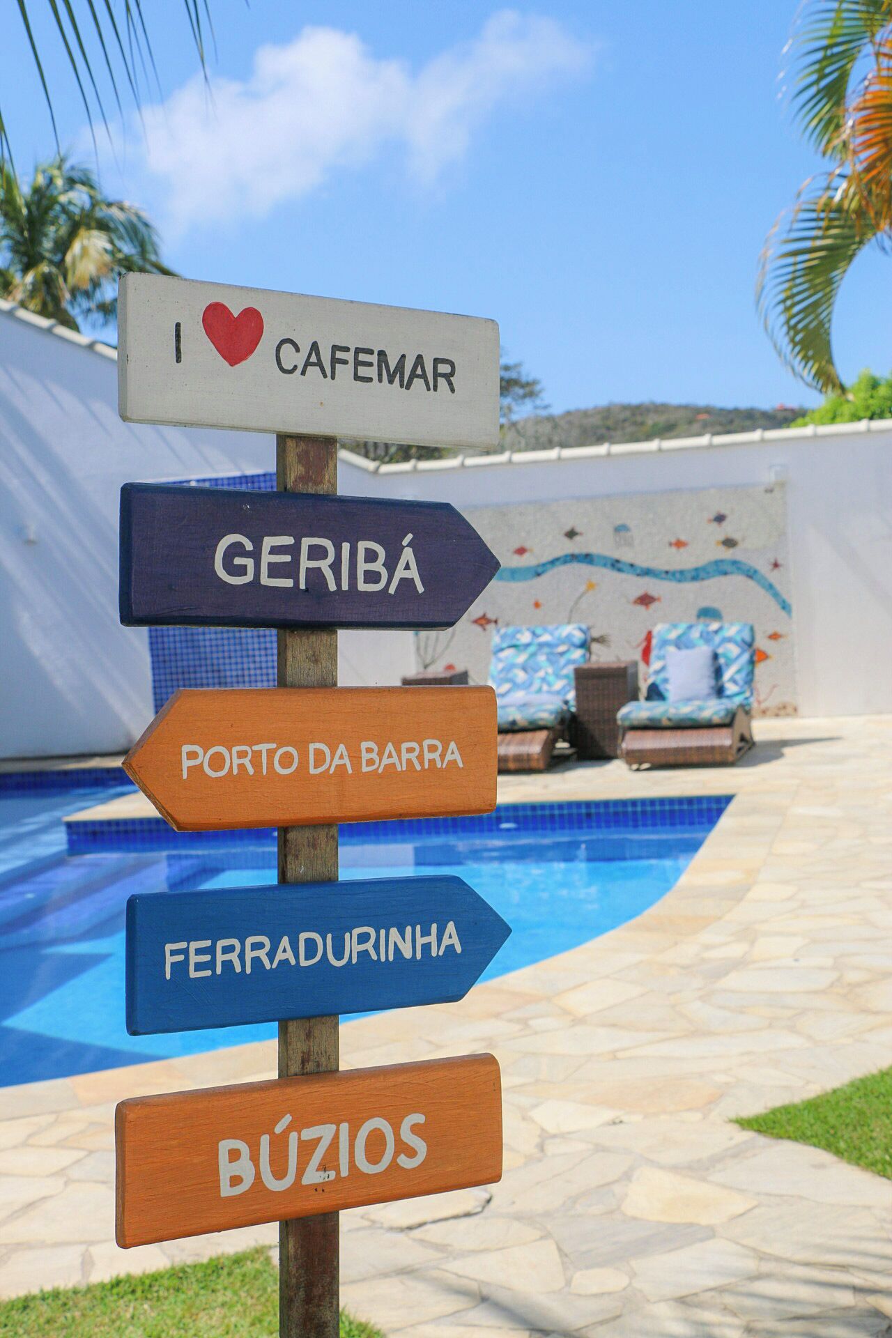 A signpost with directions to various locations including Cafemar, Geribá, Porto da Barra, Ferradurinha, and Búzios.