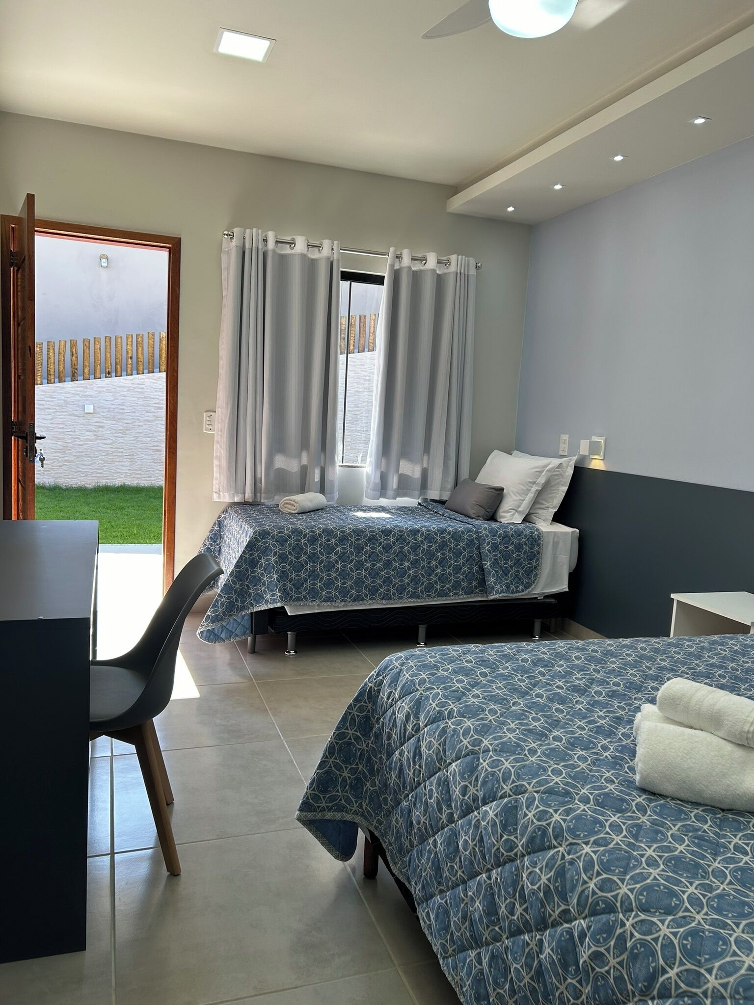 Une chambre avec deux lits, un bureau et une chaise.