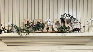 A decorative sign with the word "PEACE" spelled out in wooden letters, adorned with greenery and pinecones.