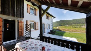 Ein rustikales Chalet mit einem Balkon mit Blick auf ein grünes Tal.