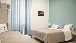 A hotel room with two beds, a wardrobe, a nightstand, and a painting on the wall. - Folklore B&B (Naples)