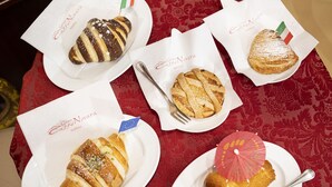 A table with five plates of pastries, each with a small flag and a name tag. - Folklore B&B (Naples)