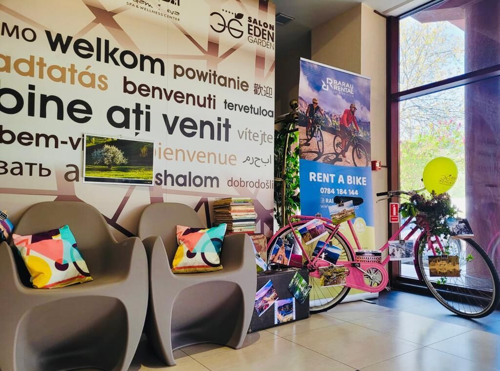 Una zona de recepció amb un cartell de 'Welcome', un cartell d' 'Rent a Bike' i una bicicleta.