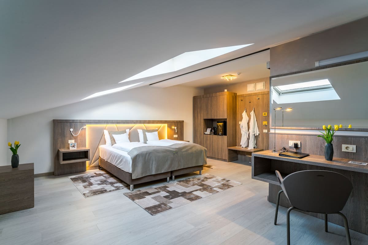 Un dormitorio moderno con una cama grande, un escritorio y un tragaluz.