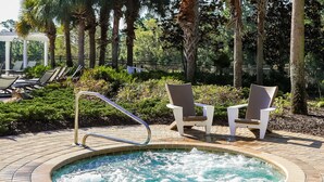 A hot tub surrounded by lounge chairs and a pergola. - Harmony Haven at Watersong (Davenport)