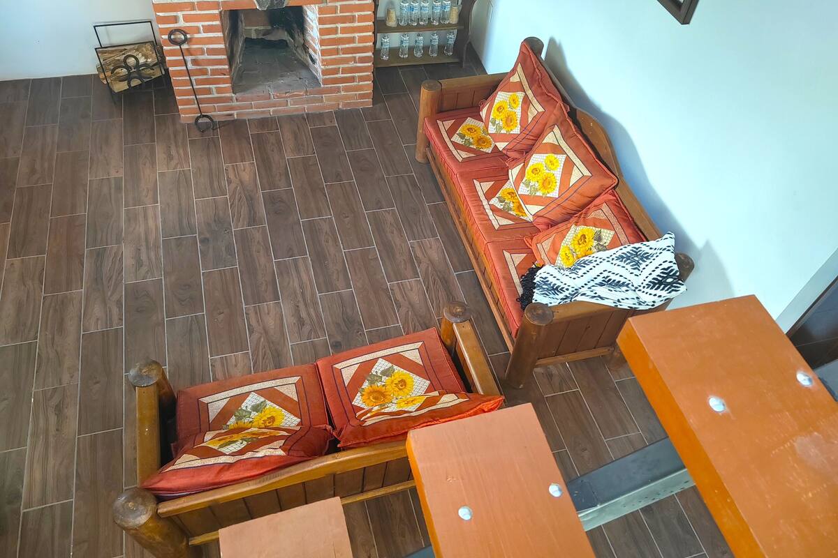 Una habitación con chimenea de ladrillo, muebles de madera y piso de baldosas.