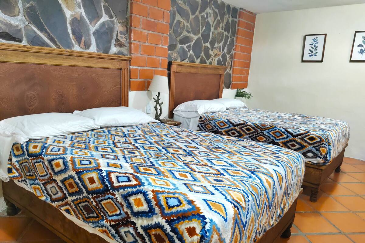 Una cama doble con ropa de cama estampada y una mesita de noche.