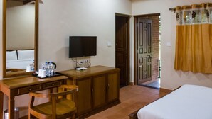 A hotel room with a wooden desk, a television, a wardrobe, and a bed. - Wildcat Tadoba Resort (Sindewahi)