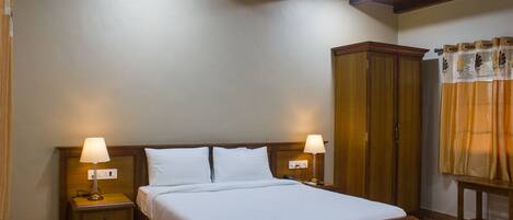 Una habitación de hotel con una cama de madera, dos mesitas de noche con lámparas, un armario y una cortina.