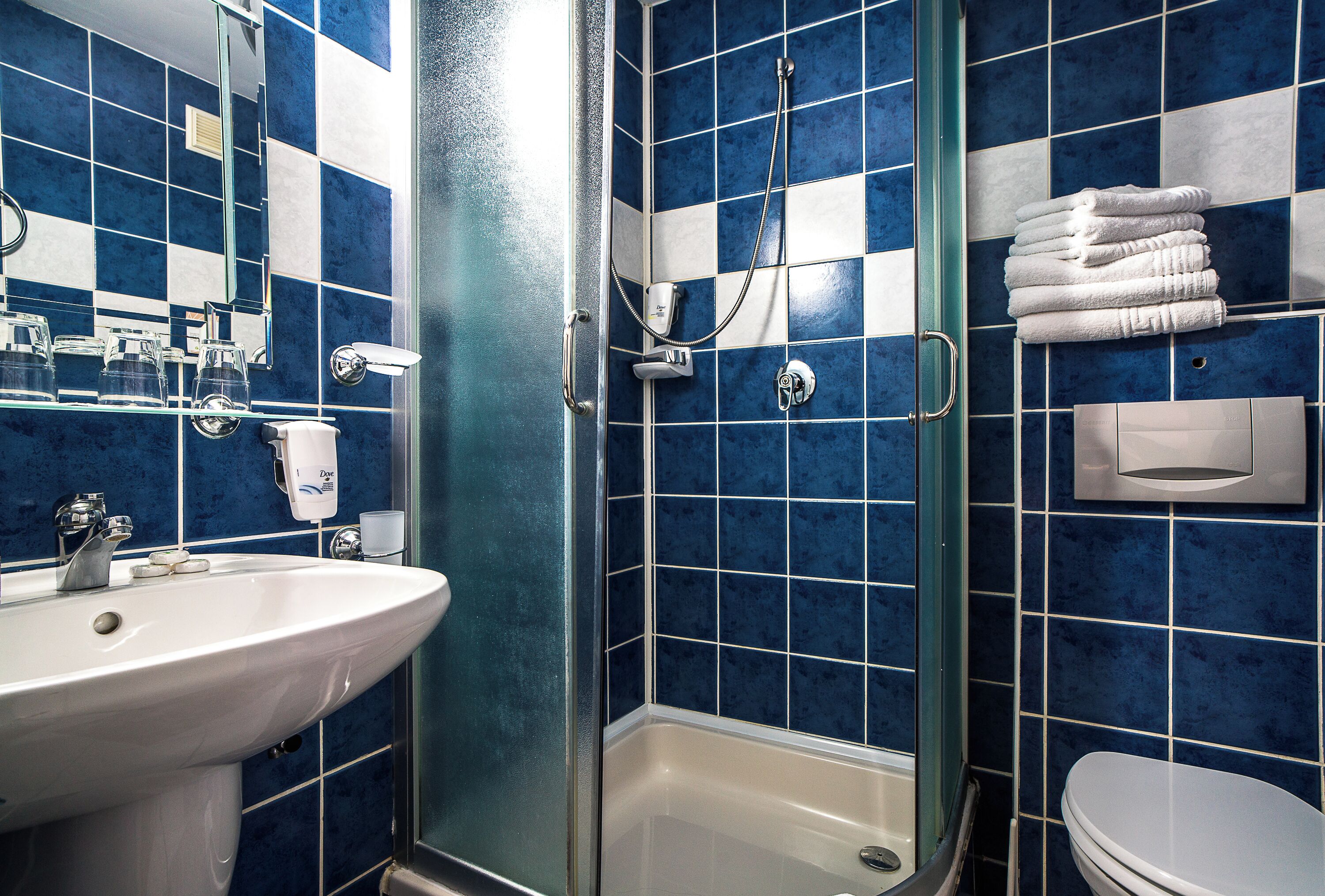 A bathroom with a sink, toilet, and shower area.