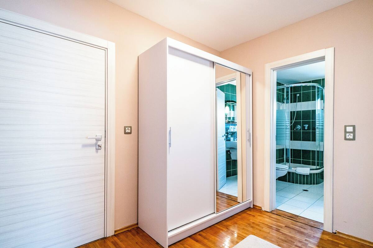 A room with a sliding door leading to a bathroom with a shower and toilet.