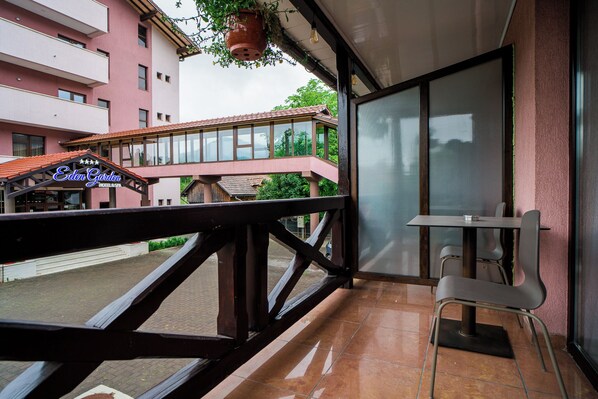 Un balcón con vista a un hotel y un edificio de enfrente.