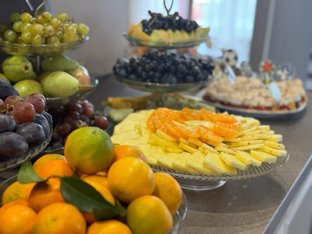 Un bufé con diversas frutas y pasteles.