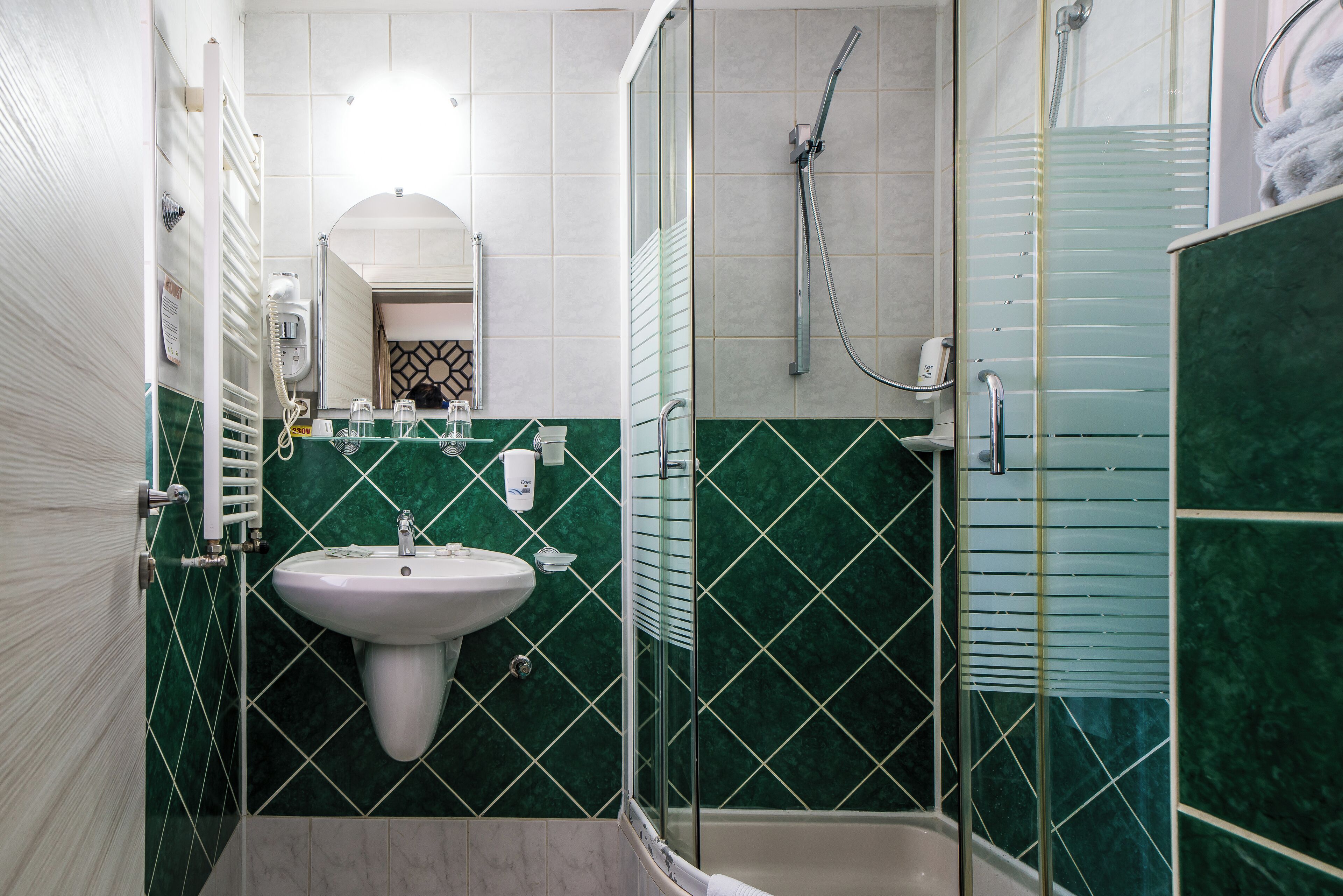 Un baño con lavamanos, espejo y ducha.