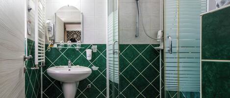 Une salle de bain avec un lavabo, un miroir et une douche.