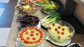 A buffet with various dishes including salads, vegetables, and dips.
