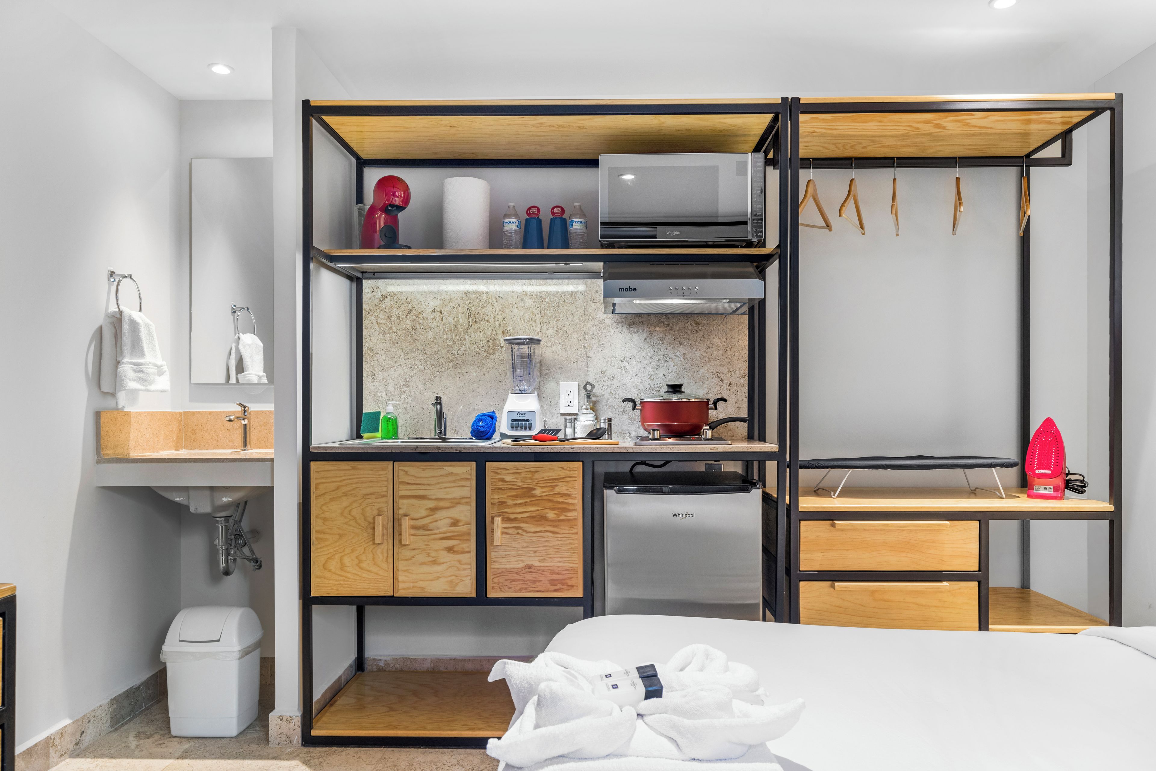 Una kitchenette compacta con microondas, tostadora y refrigerador pequeño.