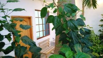 A courtyard with a wooden bench, a door, and a window.
