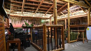 Ein Zimmer mit Bambusdecke, einem Reetdach und einem Holzboden.