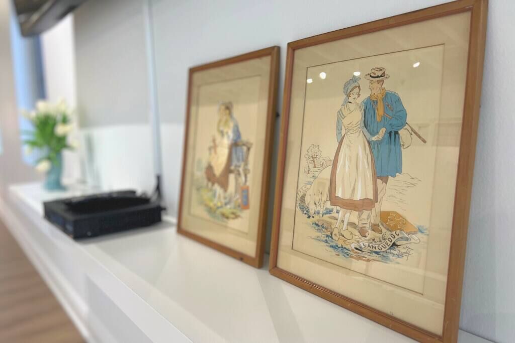 Two framed artworks on a white wall.