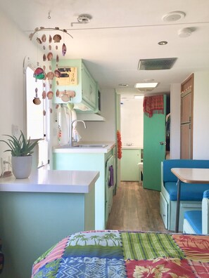 Een koelkast, een broodrooster, een blender, kookgerei, borden en bestek