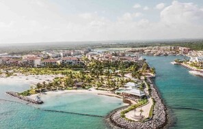 Une station balnéaire comprenant plusieurs bâtiments, un port de plaisance et une plage.