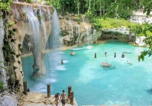 A natural pool with clear turquoise water, surrounded by rocky cliffs and lush greenery. - Cozy Retreat, 5 minutes to Juanillo Beach at Fishing Lodge Marina Cap Cana! (Punta Cana)